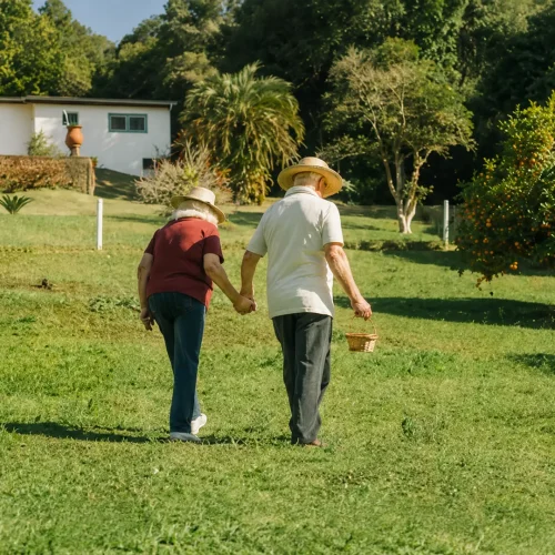 Elderly couple enjoying a walk together in a sunny care home garden