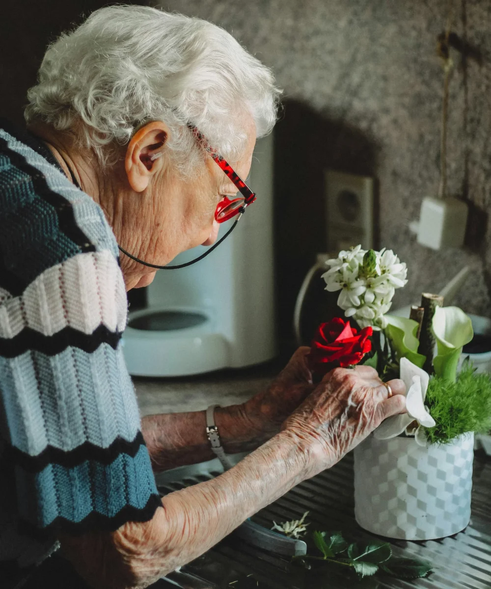 Older resident arranging flowers during an activity at Care Home Aylesbury