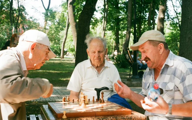 Older adults playing chess together outdoors